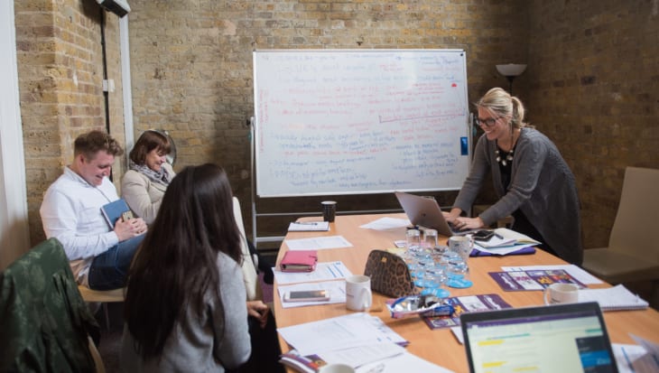 Team of Edelman staff and charity sitting around a table brainstorming