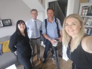 Gosia in a living room during filming, with ITV News mentor, Nick Smith, a camera man and an interviewee.