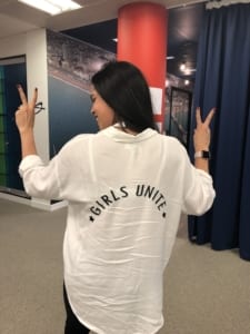 Women with "Girls Unite" written on back of shirt