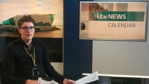 Iain sitting behind news desk at ITV news
