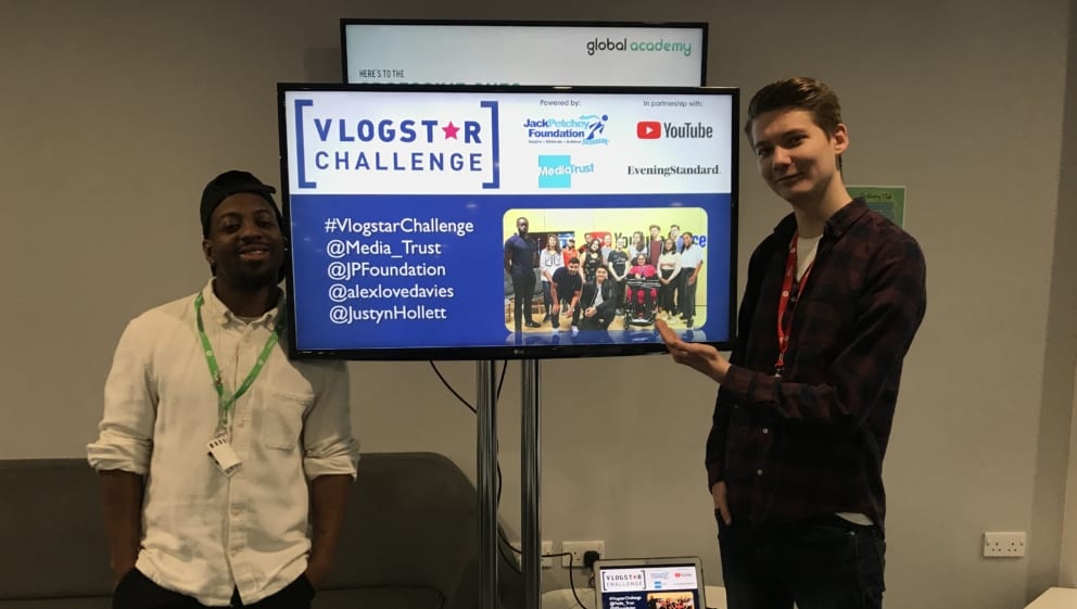 Trainers at the Vlogstar Workshop at Global academy stand either side of a screen