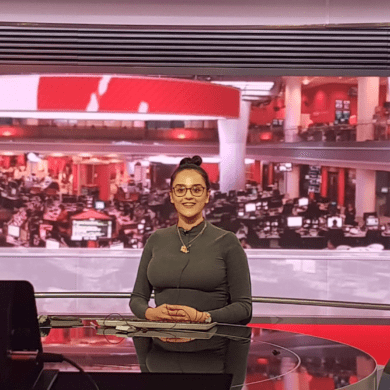 Anita sits behind the bbc news desk