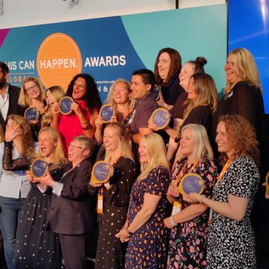 A large group of people posing with trophies at the This Can Happen Awards.
