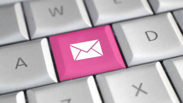 A computer keyboard with an email button in pink.