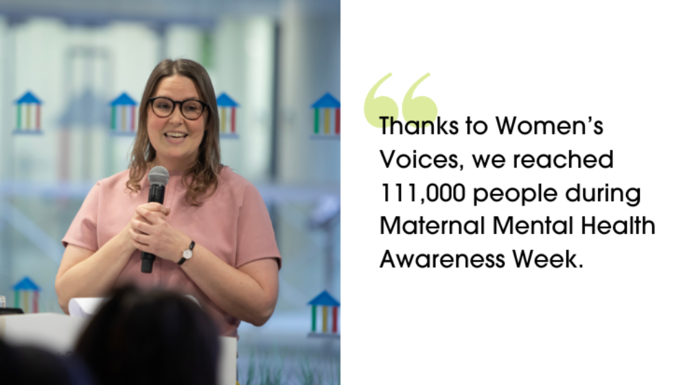 Jessie holding a microphone, smiling as she presents to a room of people at Women's Voices. "Thanks to Women’s Voices, we reached 111,000 people during Maternal Mental Health Awareness Week."