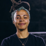 Headshot of Liz smiling, in front of a football goal.