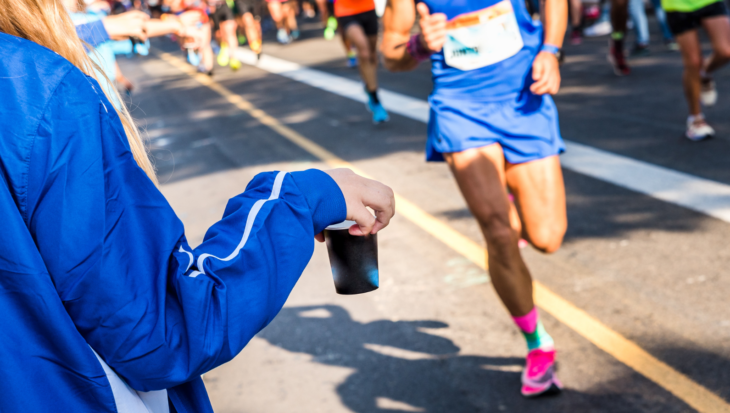 A person holding a cup of water for a charity runner