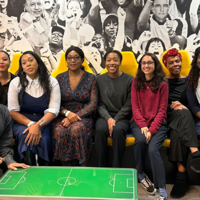 A group of people, stood and sat, as they pose for a photograph at News UK's offices