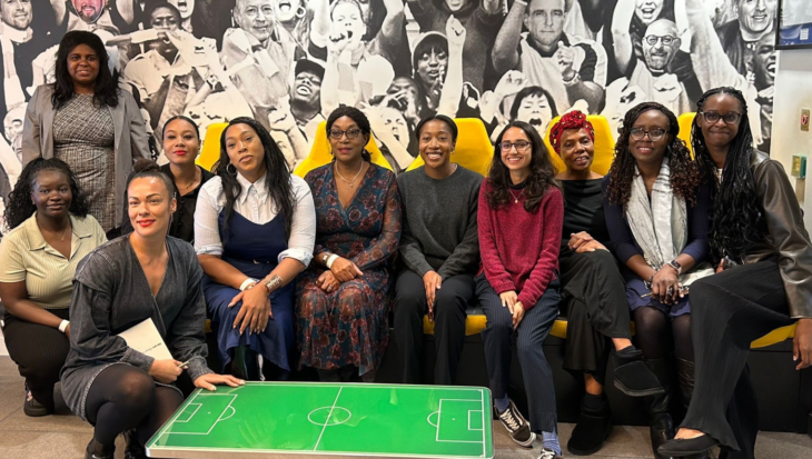 A group of people, stood and sat, as they pose for a photograph at News UK's offices