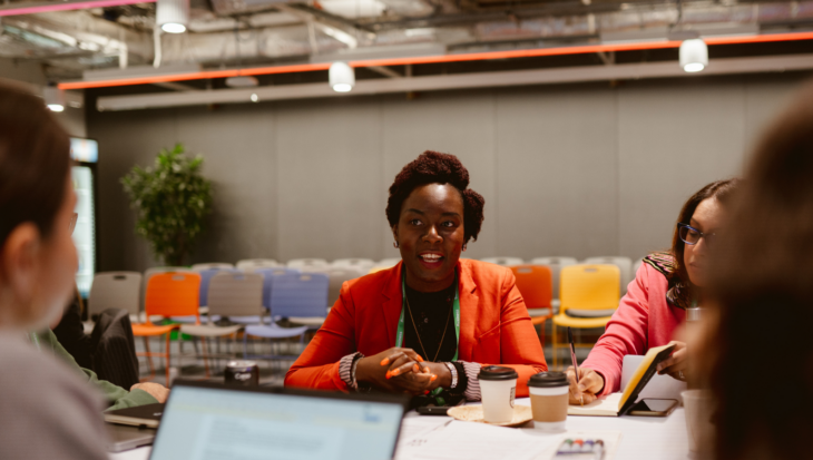 A person sat at a table, talking to others