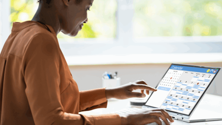 A person sat, using a digital calendar on their touchscreen laptop