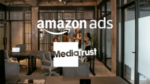 A team stood around desks, talking, in a modern office setting Amazon Ads and Media Trust logos