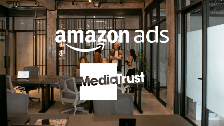 A team stood around desks, talking, in a modern office setting Amazon Ads and Media Trust logos