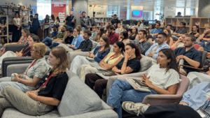 A large group of MG OMD staff sat, in the MG OMD office, watching a presentation