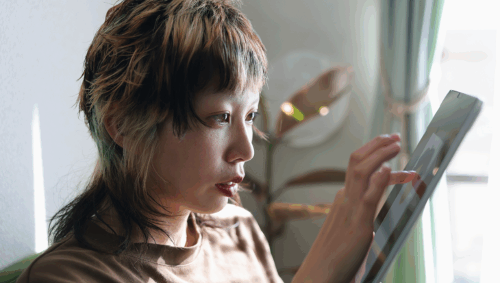 A person sat, using a tablet