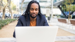 A person sat outside, working on a laptop