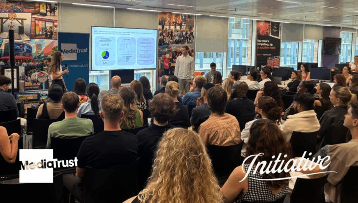 People sat in an office, watching a presentation Media Trust and Initiative logos