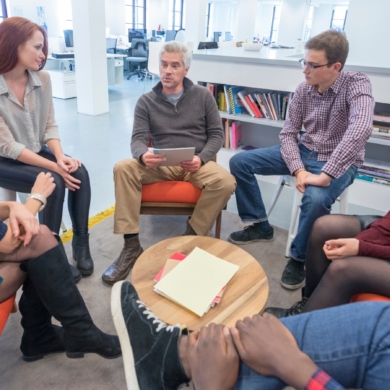 A group of people sat around a table, talking