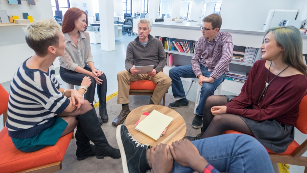 A group of people sat around a table, talking