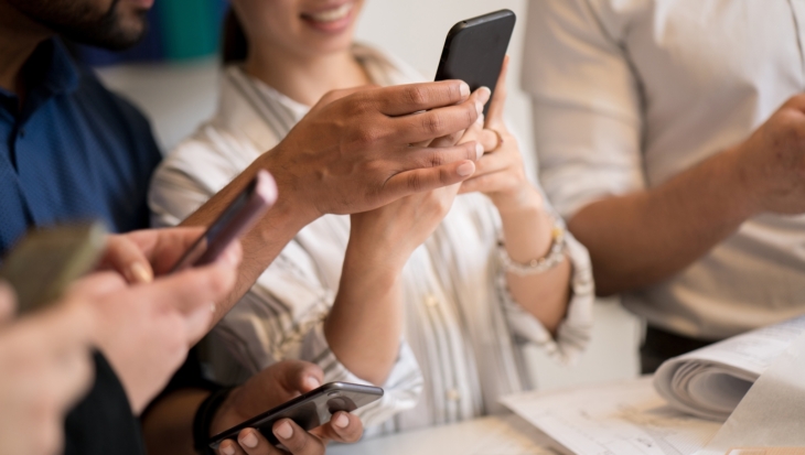 A group of people holding mobile phones