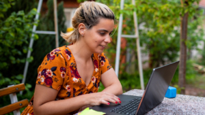 A person sat outside, using a laptop