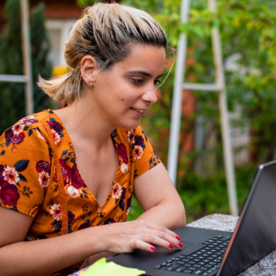 A person sat outside, using a laptop